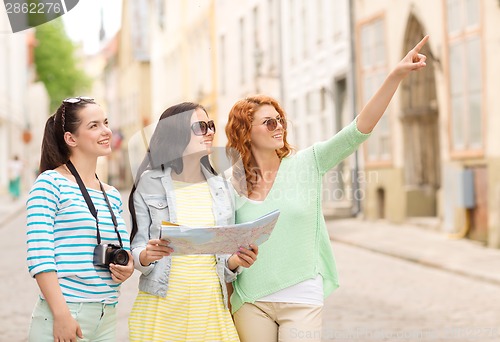 Image of smiling teenage girls with map and camera