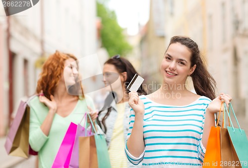 Image of smiling teenage girls with shopping bags on street