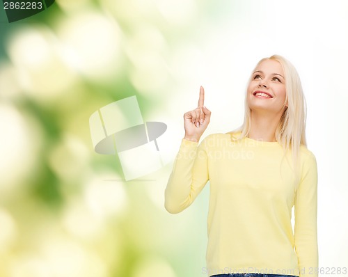 Image of smiling woman pointing her finger up