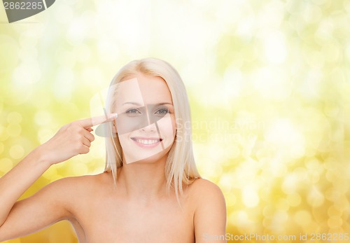 Image of beautiful woman touching her eye area