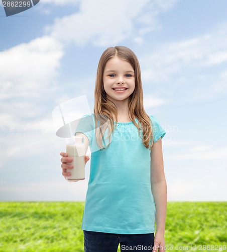 Image of smiling little girl giving glass of milk