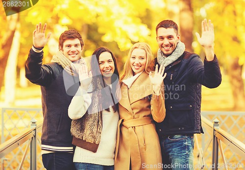 Image of group of friends having fun in autumn park