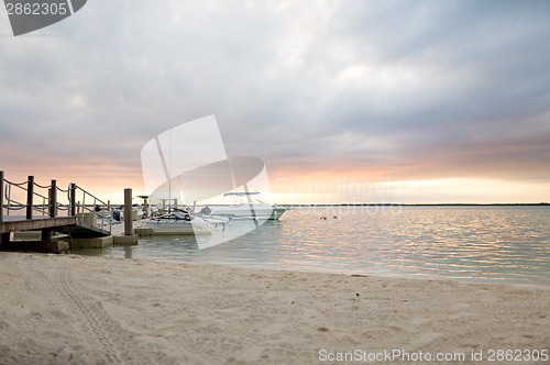 Image of boats moored to pier at sundown