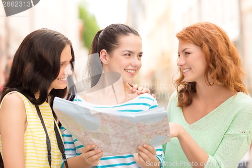 Image of smiling teenage girls with map and camera