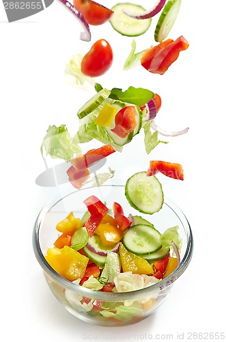 Image of Fresh vegetables falling into the glass bowl