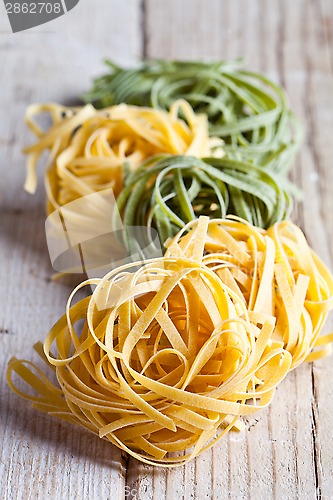 Image of yellow and green uncooked pasta tagliatelle