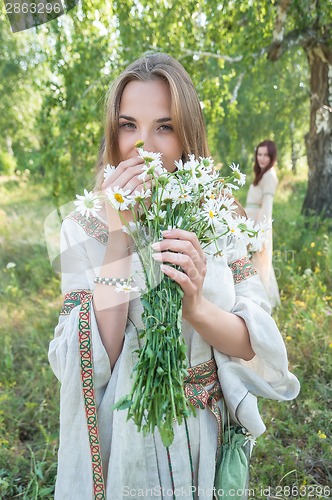 Image of Beautiful blonde woman with bouquet of camomiles