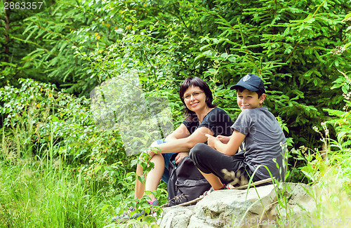 Image of Portrait of family sitting on a bridge in forest