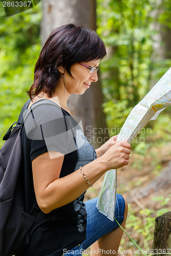 Image of Lost woman in the countryside holding a map