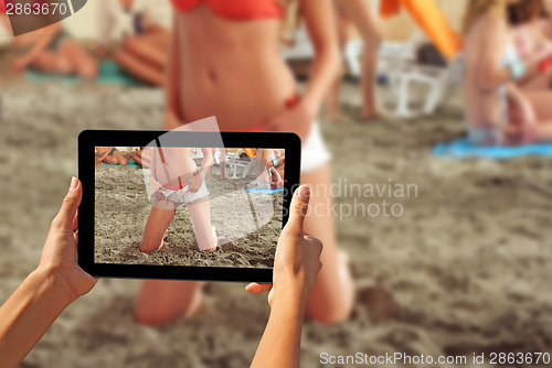 Image of Woman taking pictures on a tablet Girls on a beach