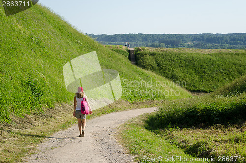 Image of tourist woman walk mound hills 