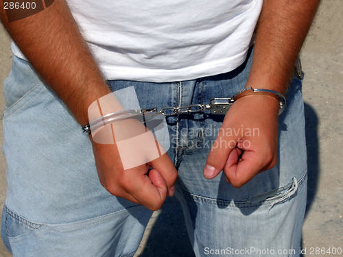 Image of Hands of the man - the criminal, chained in handcuffs