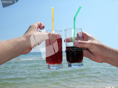 Image of Two man's hands with glasses of cocktails on a background of the