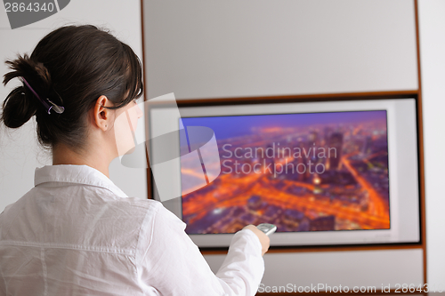Image of young woman watching tv at home