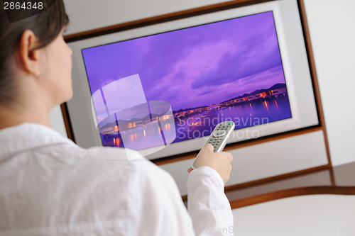 Image of young woman watching tv at home