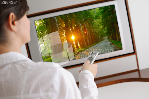 Image of young woman watching tv at home