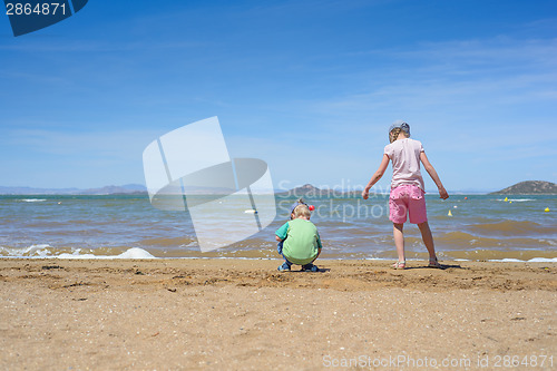 Image of Little boy and girl playing on the beach