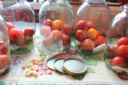 Image of tomatos in jars prepared for preservation