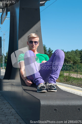 Image of Handsome blond man sitting on the seat