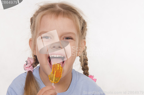 Image of Funny girl licking a lollipop