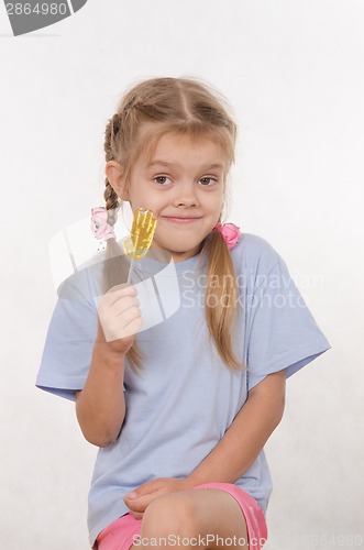 Image of Portrait of five year girl with lollipop in her hand