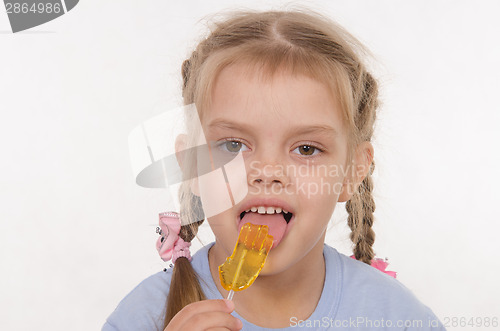 Image of Girl licking a lollipop