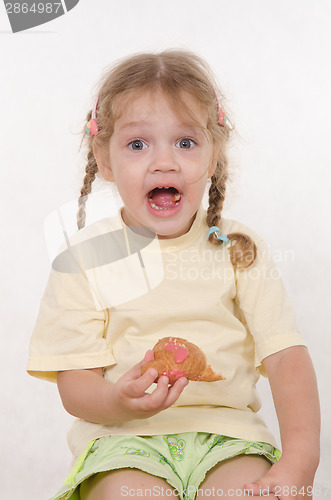Image of Fun girl opened her mouth while eating a muffin