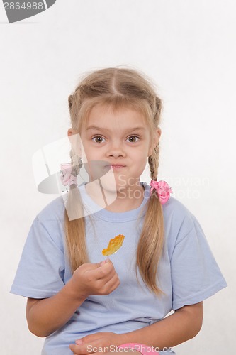 Image of Cheerful five year girl with sweet candy in hands of