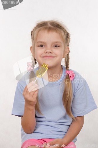 Image of Cheerful five year old girl with a lollipop