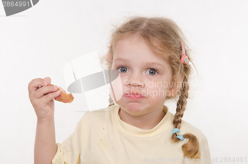 Image of Three year old girl eating a croissant