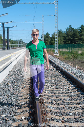 Image of Young men walking on the rail track