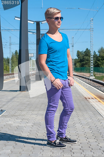 Image of Stylish man  in blue standing on train station