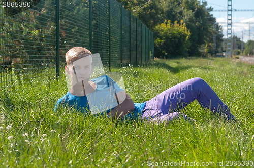 Image of Young man lying on the green grass