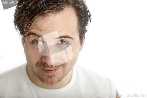 Image of Attractive man in a white shirt looks into the camera