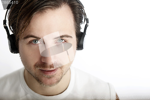 Image of Attractive man with headphones looks into the camera