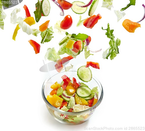 Image of Fresh vegetables falling into the glass bowl