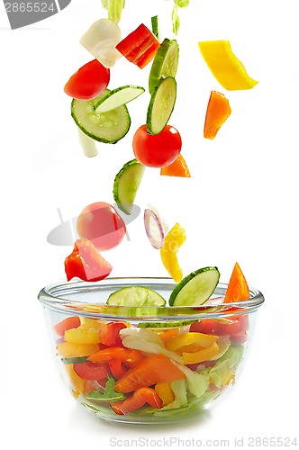 Image of Fresh vegetables falling into the glass bowl