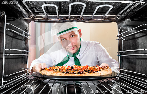 Image of Chef cooking pizza in the oven.