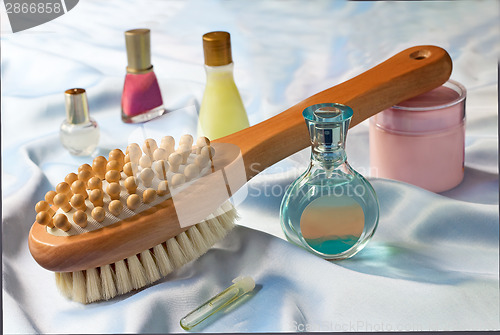 Image of Massage brush and conditioning agents behind a body.