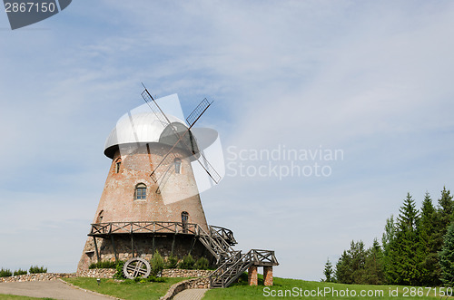 Image of big old brick mill with stairs on the summer time 