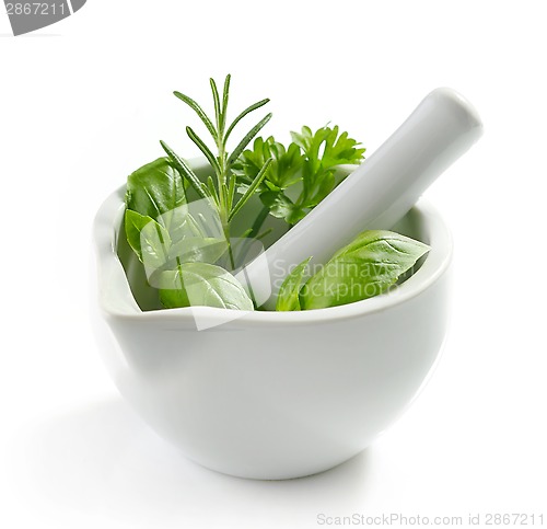 Image of green herb leaves in a white pestle