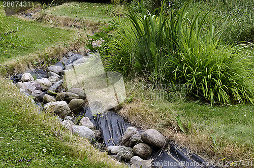 Image of artificial pond stream and decorative landscaped garden