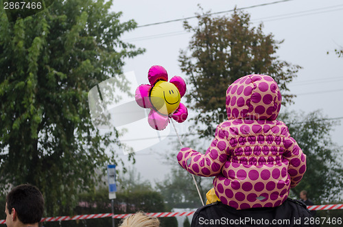 Image of girl with pink dotted jacket sit on dad shoulders 