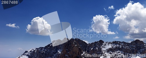 Image of Panorama of snowy rocks and blue sky with clouds