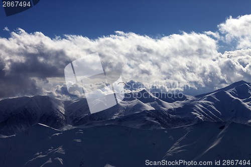 Image of Evening sunlight mountain with clouds and silhouette of parachut