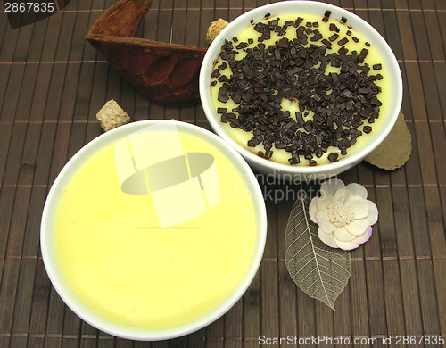 Image of Custards with and without grated chocolate in bowls of china war