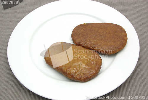 Image of Two breaded bean curd cutlets on a white plate