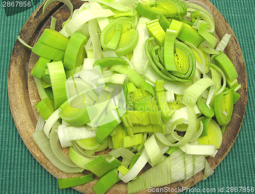 Image of SLiced green leek on a wooden plate