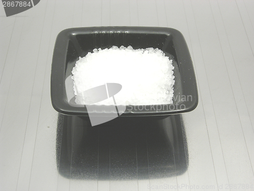 Image of Bowl of chinaware with salt on reflecting matting