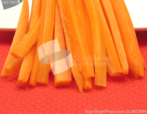 Image of Julienne carrots on a white plate and red placemat